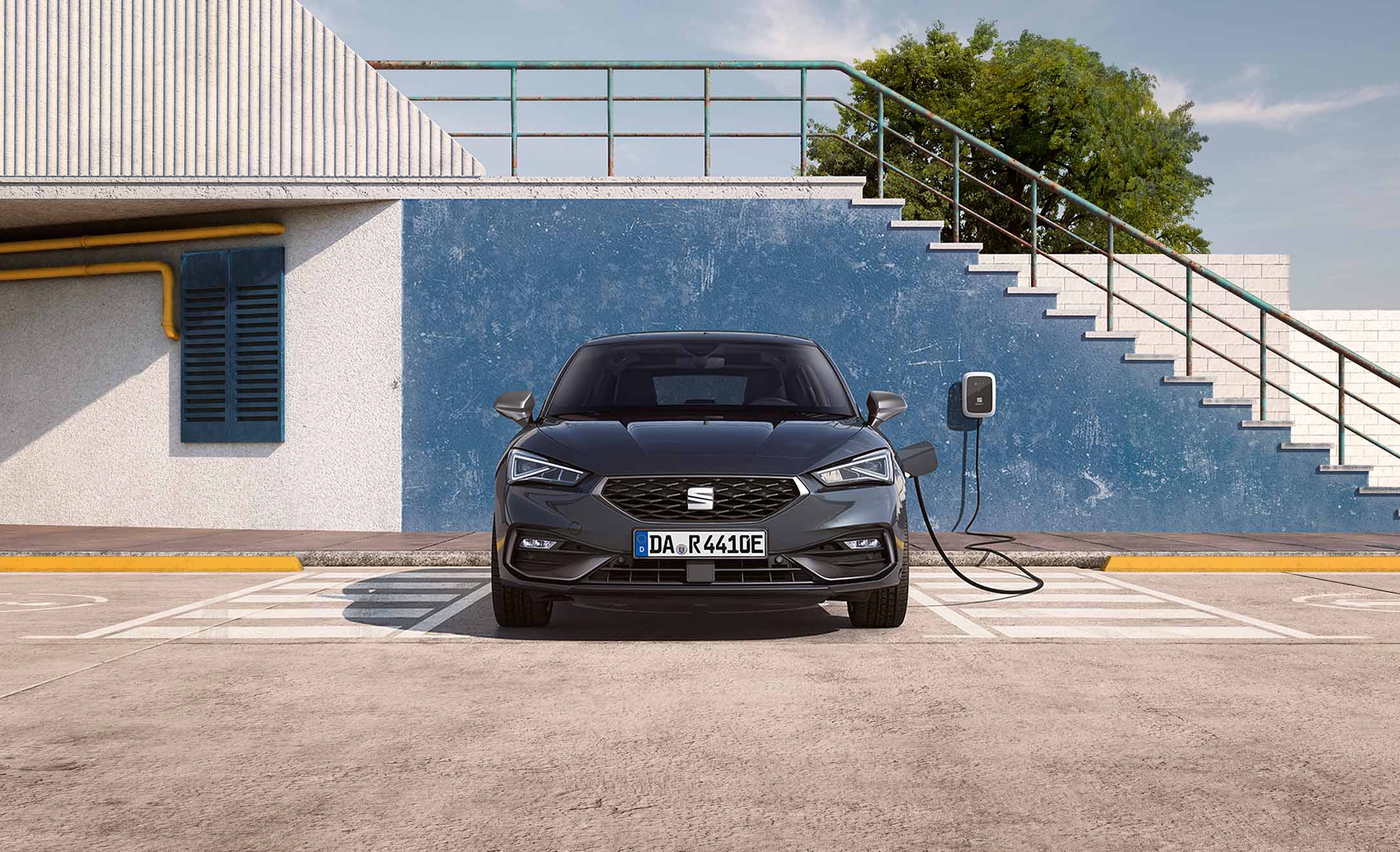 SEAT Leon e-HYBRID an der Ladesäule in sonniger urbaner Umgebung